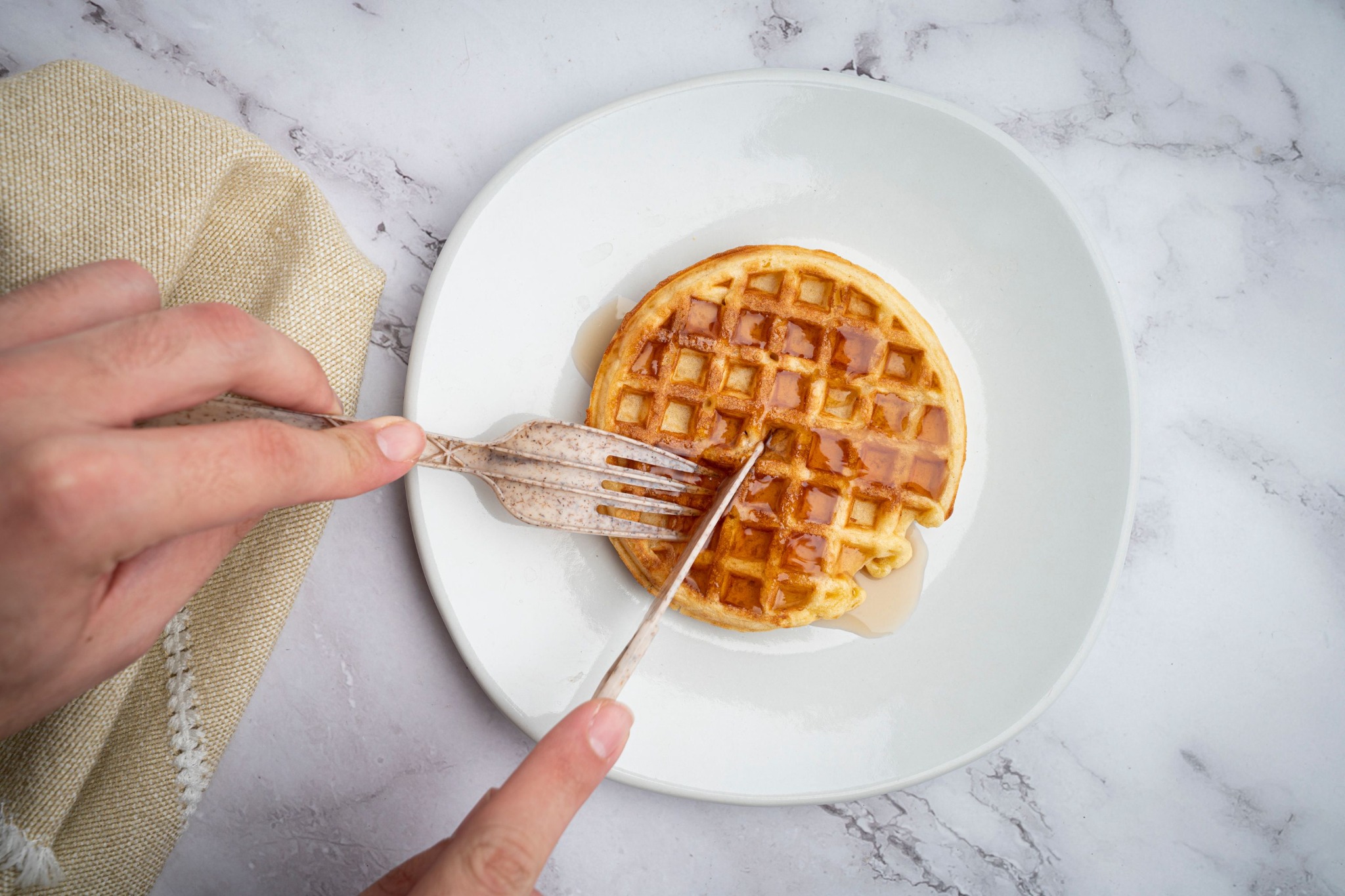 Natural agave fork and knife cutting a waffle
